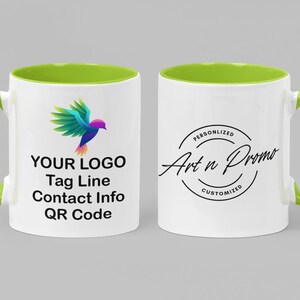 May include: A white ceramic mug with a green rim and handle. The mug has a colorful bird logo and the text "YOUR LOGO Tag Line Contact Info QR Code" on one side. The other side has a black circle with the text "PERSONALIZED Art n Promo CUSTOMIZED".