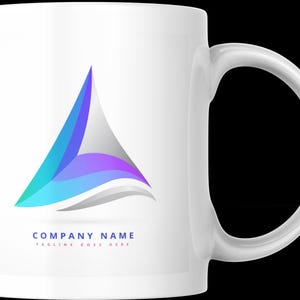Peut inclure: Une tasse en c&eacute;ramique blanche avec un logo abstrait color&eacute;. Le logo est un triangle bleu, violet et vert avec une vague blanche. Le texte "COMPANY NAME" et "TAGLINE GOES HERE" est imprim&eacute; sous le logo.
