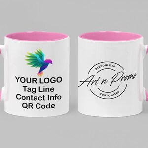 May include: White ceramic mug with a pink rim and handle. The mug features a colorful bird logo and the text "YOUR LOGO, Tag Line, Contact Info, QR Code". The opposite side of the mug has a black circle with the text "Personalized Art n Promo Customized".