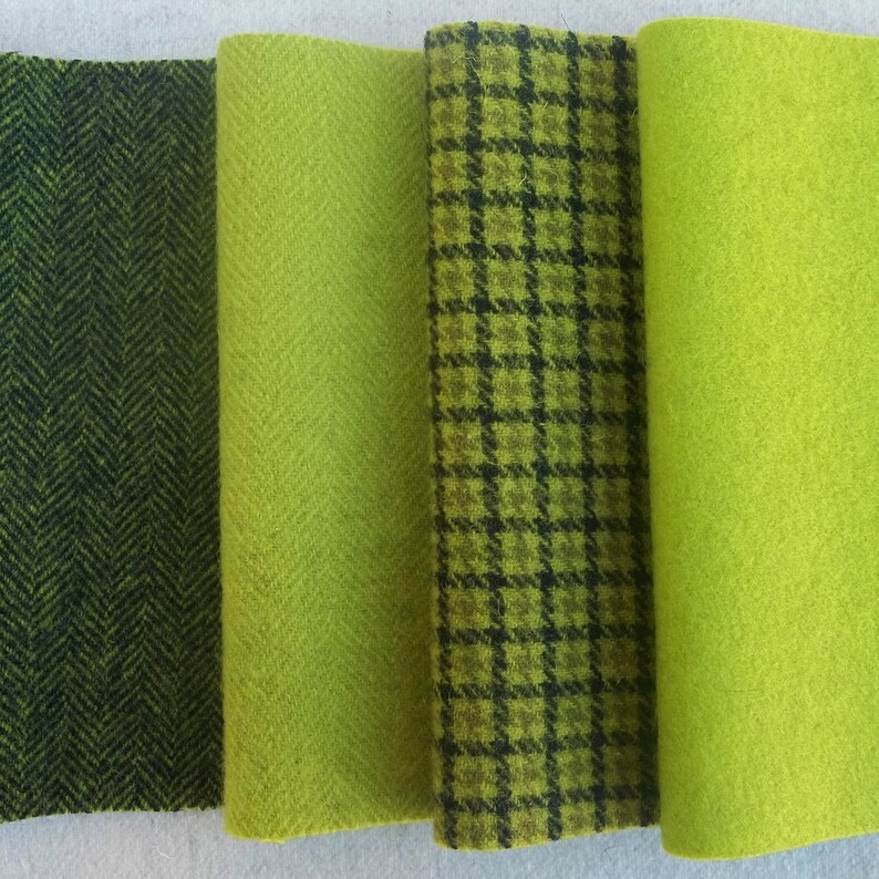 May include: Four vertical strips of fabric arranged side by side. The first is dark green with a black herringbone pattern, the second is solid lime green with a herringbone weave, the third is a lime green plaid with black lines, and the fourth is solid lime green.