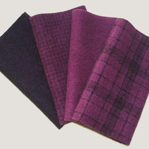 May include: Four folded fabric swatches in shades of purple. The swatches display different textures and patterns, including herringbone, houndstooth, and plaid. The fabrics range in color from deep plum to a lighter, brighter purple.