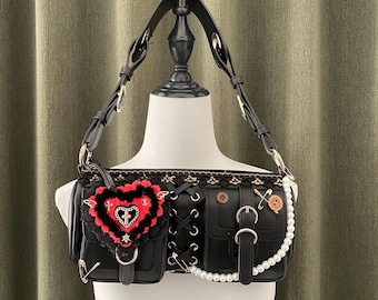 May include: A black leather handbag with a heart-shaped patch, a lace-up detail, and a pearl chain. The bag has a top handle and a shoulder strap.