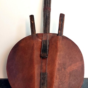 Può includere: Uno strumento musicale tradizionale africano chiamato kora. La kora è fatta di legno e pelle e ha un corpo rotondo con corde che scendono lungo il manico. La kora è uno strumento popolare nell'Africa occidentale e viene spesso utilizzata nella musica tradizionale e nelle cerimonie.