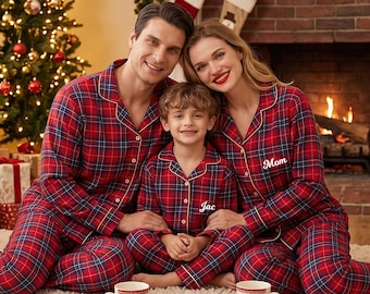 May include: Matching red, blue, and white plaid button-down pajama sets with long sleeves and pants. The shirts feature white embroidered text reading Mom and Jac. The fabric has a classic tartan pattern with a notched collar design.