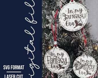 May include: Three white round ornaments with the text "In my Fantasy Era" and a bat graphic. The ornaments are hanging on a Christmas tree with red and white striped ribbon.