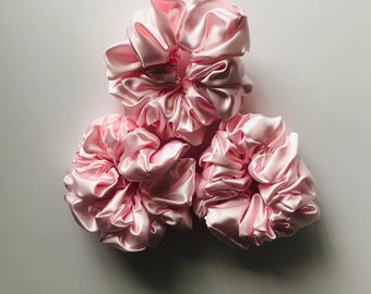 Three pink satin scrunchies