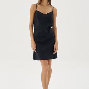 May include: A black sleeveless slip dress with a scoop neck.