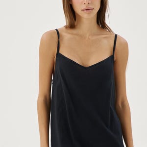 May include: A black sleeveless dress with a V-neckline. The dress is made of a soft, flowing fabric.