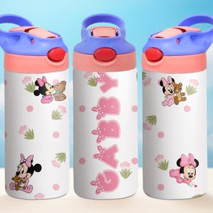 May include: Three pink and white water bottles with a blue lid and handle. Each bottle features a different image of Minnie Mouse and her friend. The middle bottle has the name "Gabby" written in pink letters.