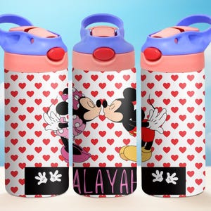 May include: Three pink and blue water bottles with a white background featuring a red heart pattern. The bottles have a Mickey Mouse and Minnie Mouse kissing graphic and the name "ALAYAH" printed on the middle bottle.