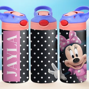 May include: Three black and white polka dot water bottles with different designs. One bottle has the name "JAYLA" in white letters on a pink background. Another bottle has a cartoon image of Minnie Mouse with a pink bow. The third bottle has a solid black and white polka dot design.