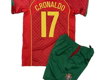Könnte beinhalten: Ein rotes Fußballtrikot mit kurzen Ärmeln, das auf der Rückseite den Namen C.RONALDO und die Nummer 17 in Gelb zeigt. Das Trikot hat grüne Ärmelabschlüsse und ein dezentes Muster. Dazu gehört eine grüne Sporthose mit einem kleinen Emblem.