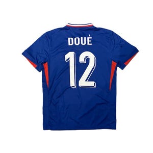 May include: A blue short-sleeved sports jersey featuring the name DOU&Eacute; and the number 12 printed in white on the back. The collar has red, white, and blue trim, and there are red accents on the sides of the garment under the sleeves.