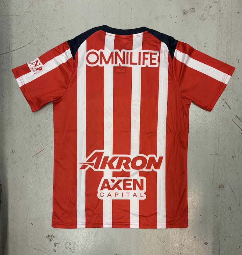 May include: Red and white striped jersey with the word "OMNILIFE" across the upper back. The jersey also features the words "AKRON", "AXEN", and "CAPITAL". The sleeves are red with white stripes.