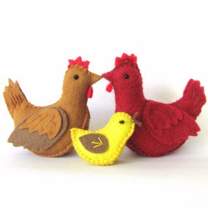 May include: A set of three felt toy chickens. The mother hen is brown, the cockerel is red, and the chick is yellow.
