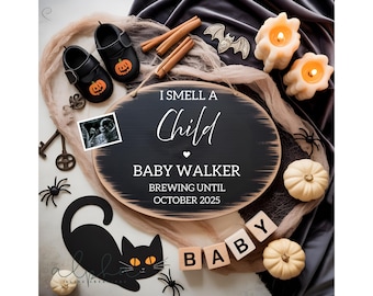 May include: An oval wooden sign with the text I SMELL A Child BABY WALKER BREWING UNTIL OCTOBER 2025, accompanied by black baby shoes with pumpkin motifs, cinnamon sticks, a bat cutout, two lit candles, a sonogram, and wooden blocks spelling BABY.