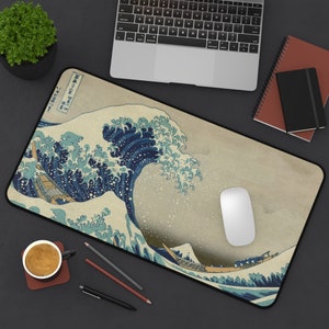 Puede incluir: Una gran ola azul rompiendo sobre un paisaje tradicional japonés. La ola está representada en un estilo clásico de impresión en madera, con un fondo beige claro. El texto "神奈川沖浪裏" es visible en la esquina superior izquierda de la imagen.