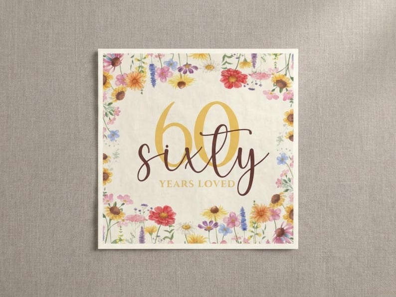 May include: A square card with a floral border featuring yellow, red, and purple flowers. The card displays the number "60" in gold script, with the word "sixty" below it, and "years loved" underneath.