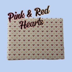 May include: A sheet of pink and red heart patterned fabric. The fabric has a white background with small pink and red hearts.