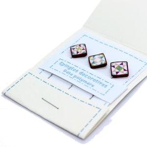 Könnte beinhalten: Drei quadratische dekorative Anstecknadeln mit geometrischen Mustern in Rosa, Grün und Weiß werden auf einer weißen Karte präsentiert. Die Anstecknadeln befinden sich vor einem weißen Hintergrund mit dem Text "Epingles décoratives pâte polymère".