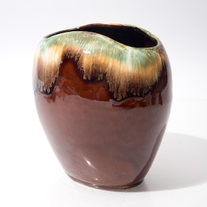 Puede incluir: Una taza de cerámica blanca con un asa negra y el texto "But First, Coffee" en negrita negra. La taza se encuentra sobre un fondo neutro, resaltando su diseño sencillo.