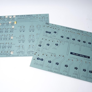 May include: Two blue and white printed charts with diagrams of rope clips, thimbles, screw hooks, and eyes. The charts are labeled "Rope Clips & Thimbles" and "Screw Hooks & Eyes". The charts also include safe working load information.