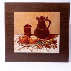 May include: A still life painting depicting a brown jug, a glass, two apples, and walnuts on a red and white checked tablecloth.