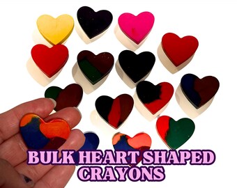 May include: A collection of heart-shaped crayons in various colors, including red, yellow, green, blue, black, and pink. The crayons are arranged in a circle on a white background. The text "BULK HEART SHAPED CRAYONS" is written below the crayons.