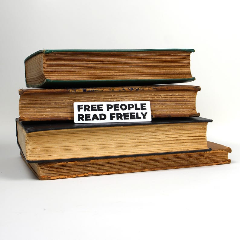 May include: A stack of three old, worn books with a white sticker on the second book that reads "FREE PEOPLE READ FREELY".