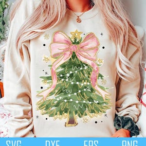 May include: A watercolor illustration of a Christmas tree with a large pink bow and gold glitter. The tree is decorated with white lights and gold stars.