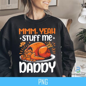 May include: Black sweatshirt with a Thanksgiving-themed graphic. The graphic features a roasted turkey with the text "MMM, YEAH stuff me DADDY".