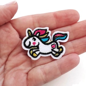May include: A white unicorn with a rainbow mane and tail. The unicorn is running and has a pink heart on its rump. The patch is iron-on and perfect for adding a touch of whimsy to clothing, bags, or other fabric items.