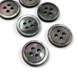 May include: Six black and iridescent shell buttons with four holes each.