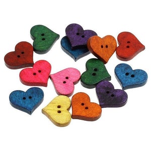 Peut inclure: Assortiment de boutons en bois en forme de cœur de différentes couleurs, dont le rouge, le rose, le bleu, le vert, l'orange et le violet. Chaque bouton a deux trous.