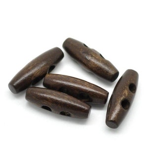 May include: Five brown wooden toggle buttons with two holes each. The buttons are oval shaped and have a smooth, polished finish.