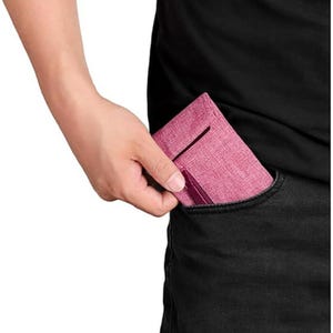 May include: A slim, rectangular wallet in a textured, dusty rose fabric. The wallet features a vertical slot on the front and a darker, solid-colored accent strip along the bottom edge, designed to fit compactly inside a pocket.