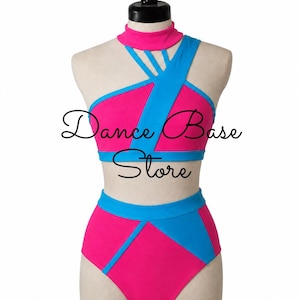 May include: A two-piece dance outfit featuring a bright pink and blue color scheme. The top has a mock neck, crisscross straps, and a wide blue band. The high-waisted bottoms feature blue diagonal paneling. The text "Dance Base Store" is visible.