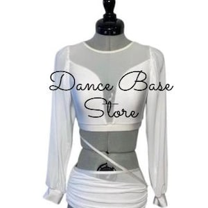 May include: A white two-piece dance outfit featuring a long-sleeved crop top with sheer mesh panels at the neckline and sleeves, paired with a matching ruched skirt. The text "Dance Base Store" is overlaid across the center of the garment.