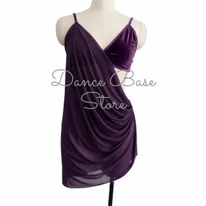 May include: A deep purple dance dress featuring a velvet bodice and a draped, semi-sheer mesh skirt with thin spaghetti straps. The garment displays the text Dance Base Store across the front. The design includes a side cutout and a layered skirt.