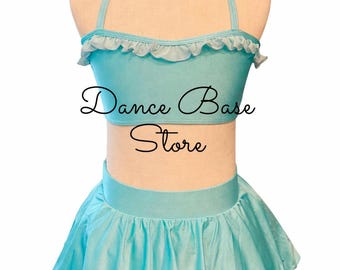 May include: A light blue two-piece dance outfit on a mannequin, featuring a halter-style crop top with a ruffled neckline and a matching pleated skirt. The text "Dance Base Store" is printed in black script across the center of the top.