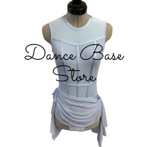 May include: A light blue sleeveless leotard featuring a corset-style bodice with vertical seams and a draped fabric skirt overlay. The text "Dance Base Store" is printed in black across the center of the garment, which is displayed on a mannequin.