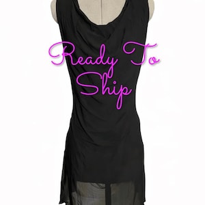 May include: A sleeveless black dress with a draped cowl neckline and a sheer hemline. The text Ready To Ship is written across the front in bright pink cursive lettering. The garment is displayed on a mannequin torso.