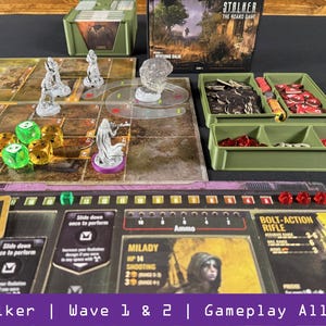 Puede incluir: Una configuración de juego de mesa con varios componentes. El juego incluye un tablero, miniaturas, dados y contenedores llenos de piezas de juego. La ilustración de la caja presenta un paisaje desolado. El texto en el tablero dice "Stalker | Wave 1 & 2 | Gameplay All-in".