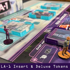 Op de afbeelding: Een bordspel met een stadsplattegrondontwerp, met miniatuurfiguren en kaarthouders. Het spelbord heeft tekst die "LA-1" en "Old Angeles" luidt. Het spel bevat miniatuurfiguren en kaarthouders. De tekst "LA-1 Insert & Deluxe Tokens" staat onderaan.