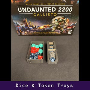 Peut inclure: Bo&icirc;te de jeu de soci&eacute;t&eacute; "Undaunted 2200 Callisto" avec des d&eacute;s et des plateaux de jetons. Les plateaux gris contiennent des d&eacute;s rouges, bleus et verts, ainsi que des jetons de jeu. Le texte "Dice & Token Trays" est en bas.