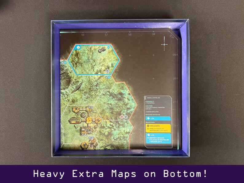Peut inclure: Un plateau de jeu avec une carte d&eacute;taill&eacute;e, pr&eacute;sentant des zones hexagonales et diverses ic&ocirc;nes. Le plateau est contenu dans une bo&icirc;te &agrave; bord bleu. Le texte en bas indique "Heavy Extra Maps on Bottom!"