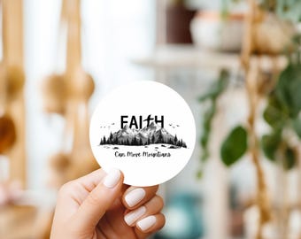 May include: White round sticker with a black and white mountain range illustration and the text "FAITH Can Move Mountains".