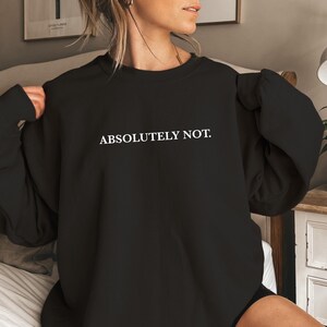 Puede incluir: Sudadera negra de gran tama&ntilde;o con el texto "ABSOLUTELY NOT." impreso en blanco en la parte delantera.