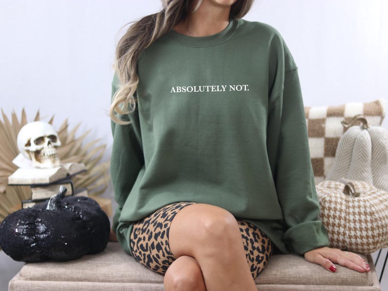 Puede incluir: Una sudadera verde con el texto "ABSOLUTELY NOT." en letras blancas. La sudadera se lleva sobre un pantal&oacute;n corto de estampado de leopardo.