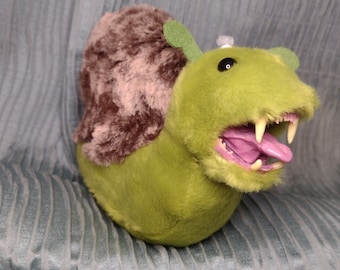 ¡Kauri-0n, el caracol carnívoro! Caracol de peluche de calidad, de 15 cm de largo, verde con caparazón marrón, con colmillos.